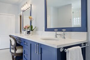 Modern bathroom vanity with blue cabinets and white countertop.