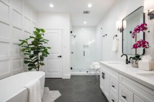 Bright modern bathroom with white cabinetry and glass shower.
