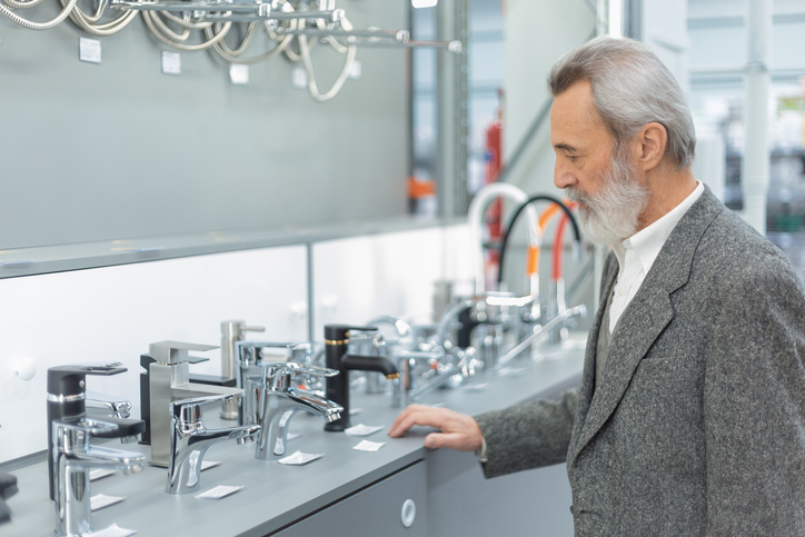 Senior man browsing bathroom faucet display